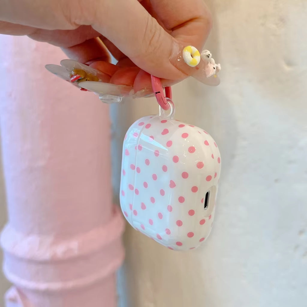 User in a stylish setting holding the White and Pink Dopamine Dot Case, showcasing the attached circular connector loop, lifestyle shot.