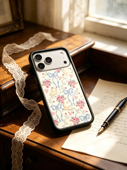 The CasePoppi The Dove's Letter vintage floral and blue ribbon case displayed on a dark wooden desk next to a retro fountain pen and old manuscript.
