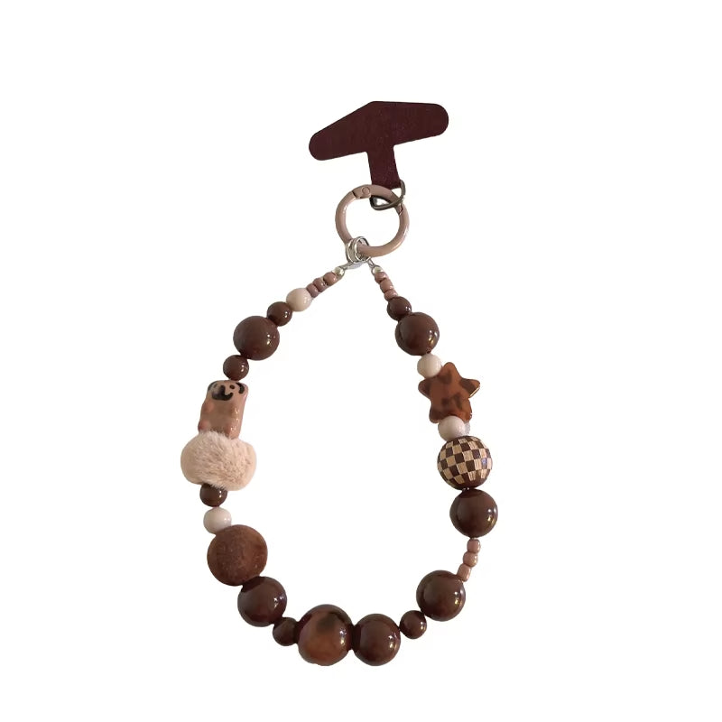 CasePoppi Cozy Milk Tea Beaded Phone Charm, featuring soft fluffy pompom beads, matte brown wood beads, houndstooth patterned beads, and natural stone accents.
