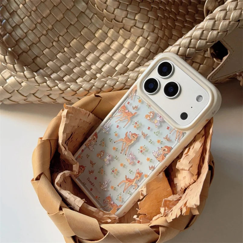 Aesthetic brown phone case for iPhone 17 Pro Max, featuring cute Bambi and woodland animal pattern, leaning against a cream woven tote bag, protective and cute style.