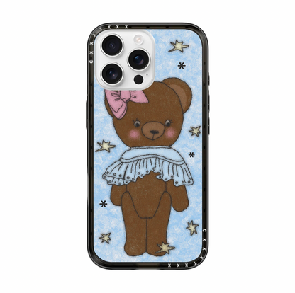 Front view of an iPhone case featuring a full illustration of a standing brown teddy bear. The bear wears a pink bow on its left ear and a detailed white eyelet lace collar. The backdrop is a soft blue textured pattern with various small floating colorful stars and dots. The case has a thick black protective bumper.