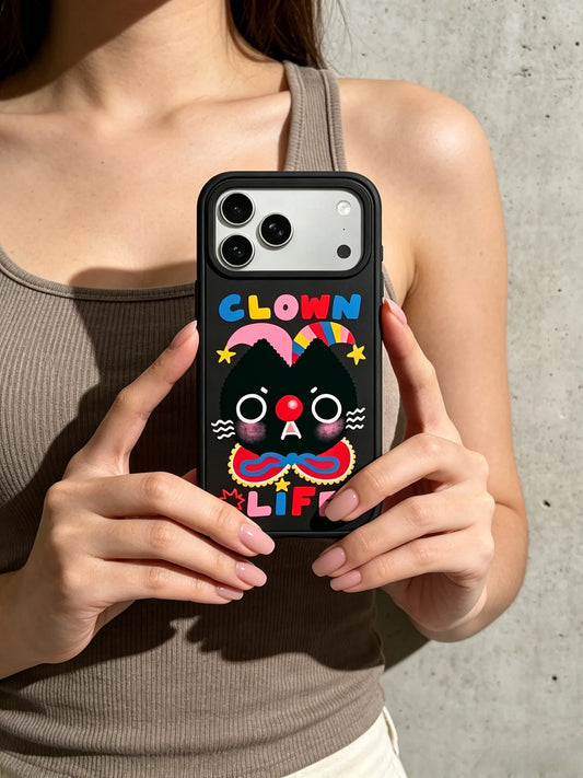 A close-up shot of a woman holding a black phone case featuring a funny black cat illustration and Clown Life typography text.