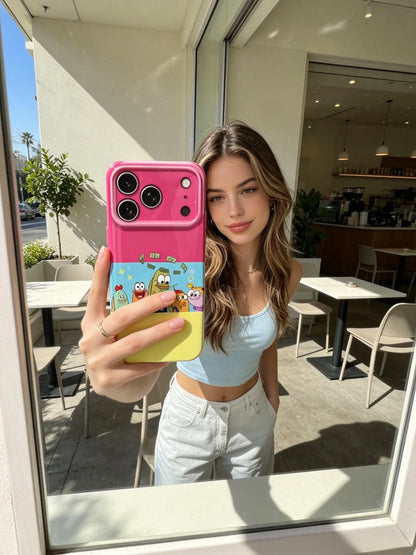 An aesthetic window mirror selfie of a young woman at an outdoor cafe, showing off a bright pink and yellow block cartoon phone case.