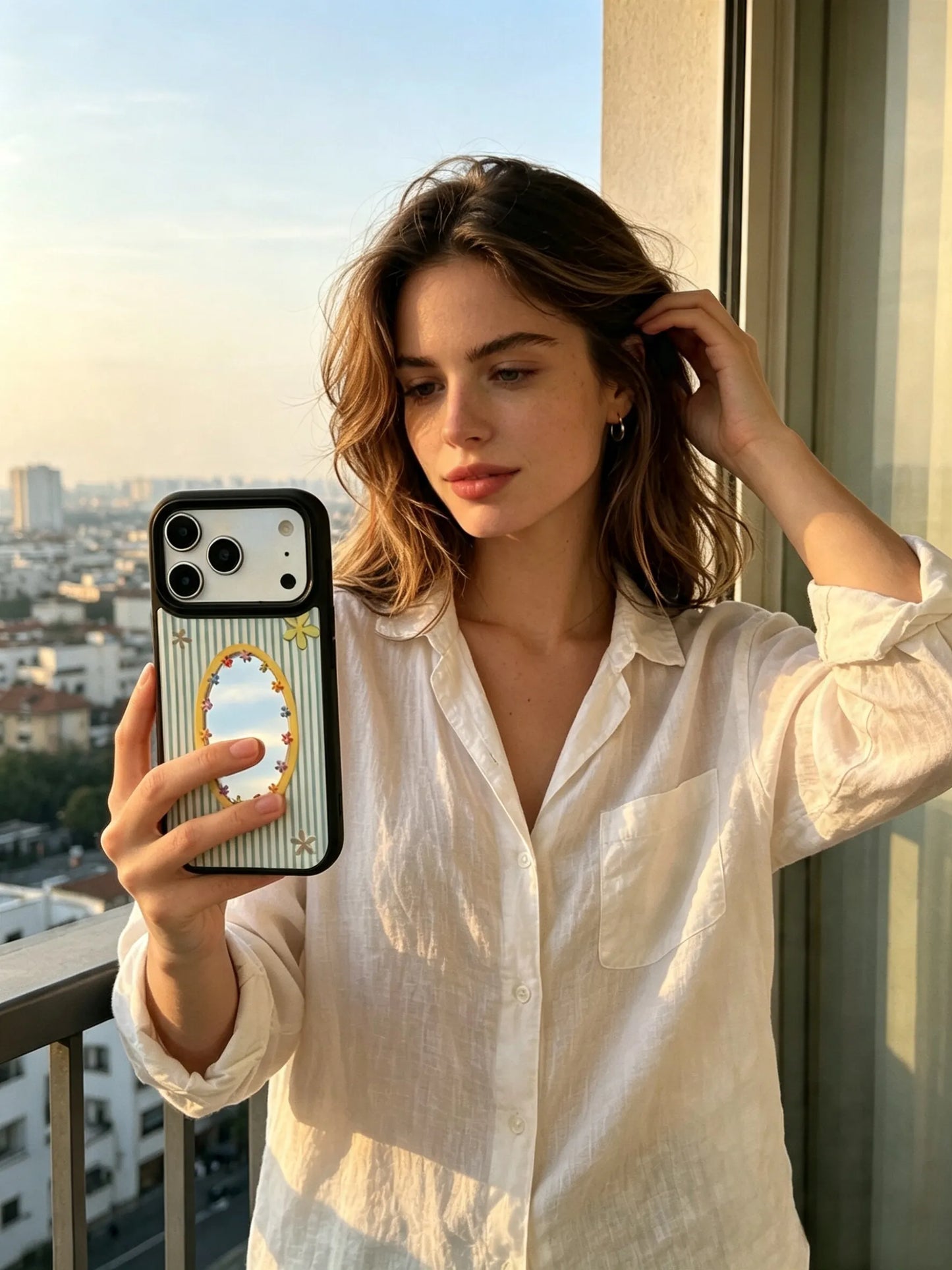 Woman holding sage green striped mirror phone case by window